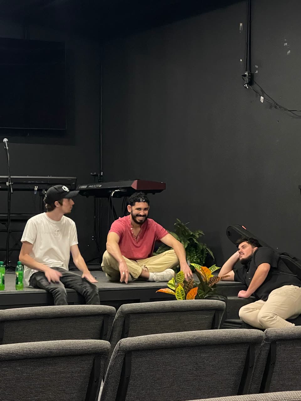Andrew sitting with two other volunteers inside Essential Church