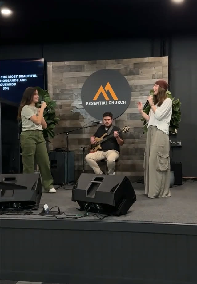 Hailey singing onstage with another vocalist at Essential Church